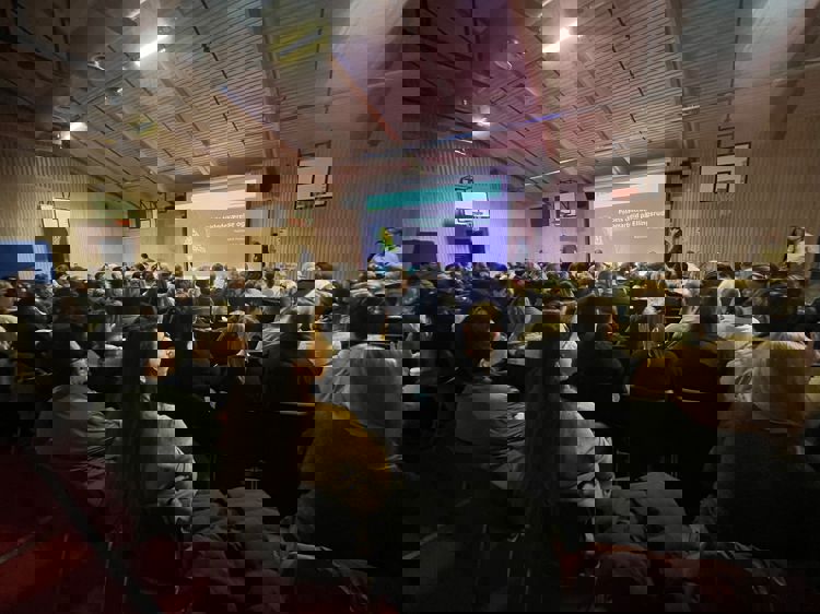 en gruppe mennesker som sitter i et rom med en skjerm og en gruppe mennesker foran en gruppe mennesker som sitter i et rom med en skjerm og en gruppe mennesker foran