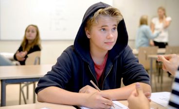 Elev i klasserom. Ung gutt skriver.