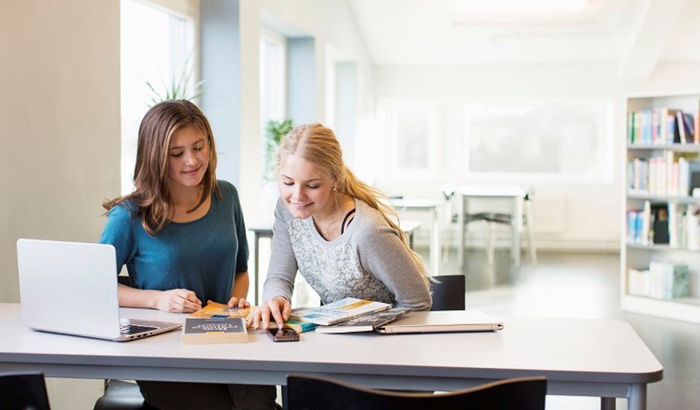 Foto: NTB scanpix Credit: Oslo kommune To jenter hjelper hverandre med lekser.